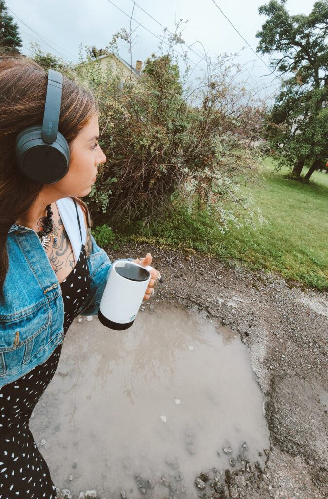 Nicole walks on a gloomy day with her black coffee