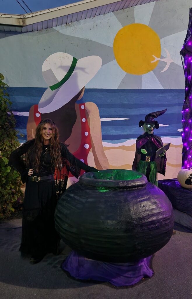 Nicole stands by a cauldron downtown for Witches Night Out