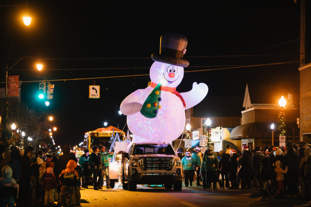 A giant inflatable snowman in the 2024 Holiday Parade in downtown Alpena